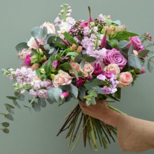 Divine Fleurs employee hand holding freshly cut colorful bouquet of flowers