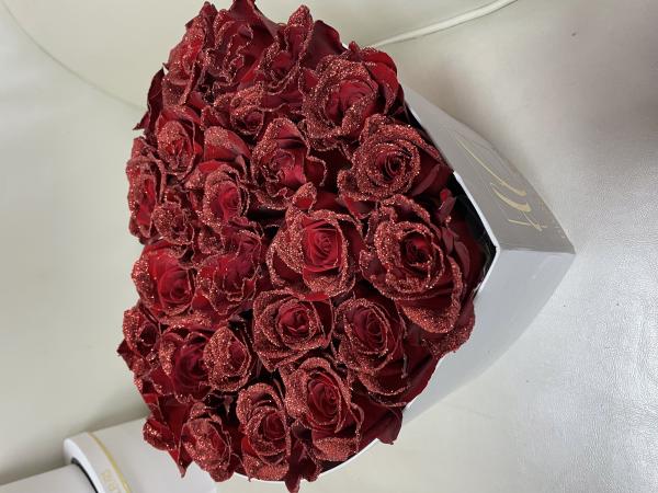 beautiful heart shaped box filled with super sparking glitter tipped red roses.