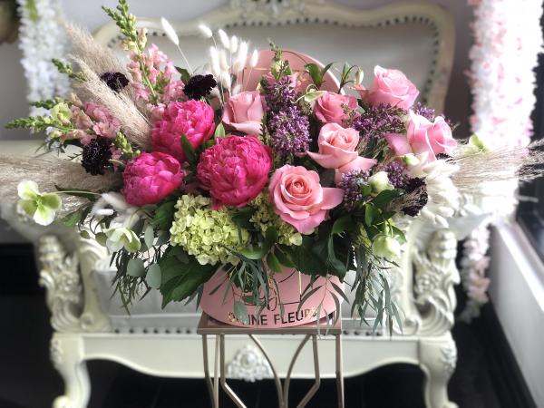 Pink Peony and dusty pink roses are set with wildflowers, bunny tails, and Pampas grass.