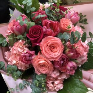 coral, hot pink and flame roses mixed with other coral and pink flowers.