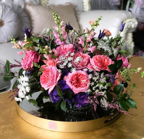 Garden roses and deep purple hydrangea set in a low-cut glass crystal bowl