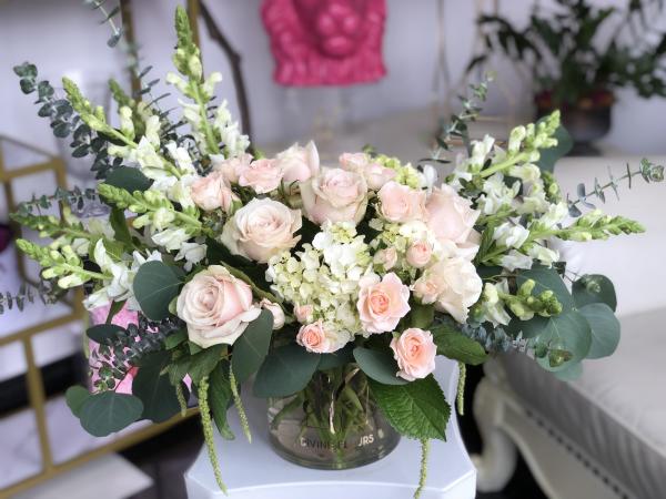 Soft Peach roses are complemented with creamy white Snapdragons, hydrangea, spray roses and mixed greens