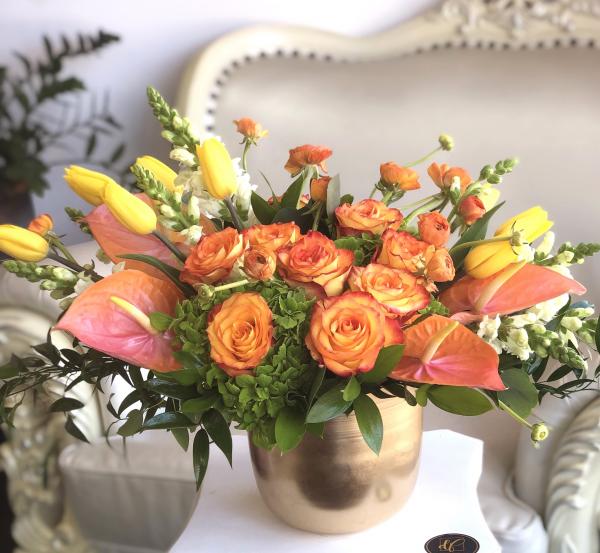 Bi-color orange roses, lush hydrangea, tropical orange or pink anthurium, yellow tulips, orange ranunculus, and touches of white snaps