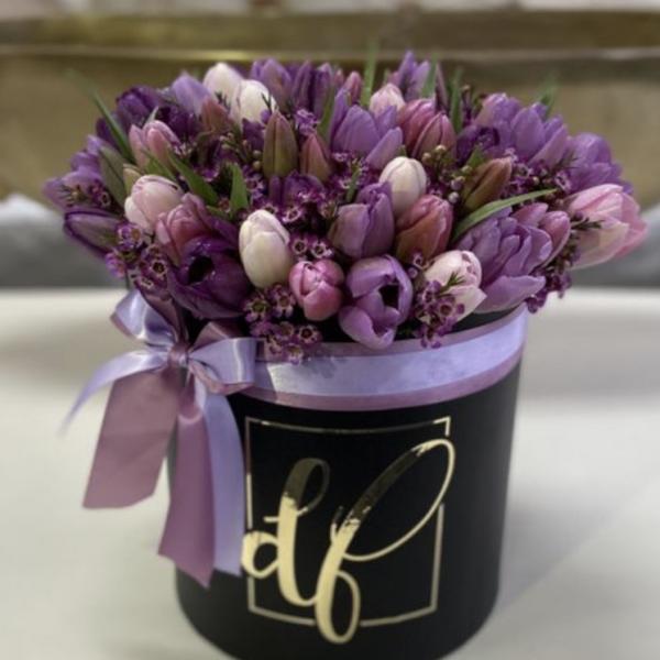Purple, lavender, and pink tulips, all tied up in a stunning black hat box.